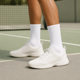 Weiße hohe RUNOX Tennissocken im Crew-Schnitt auf einem Tennisplatz